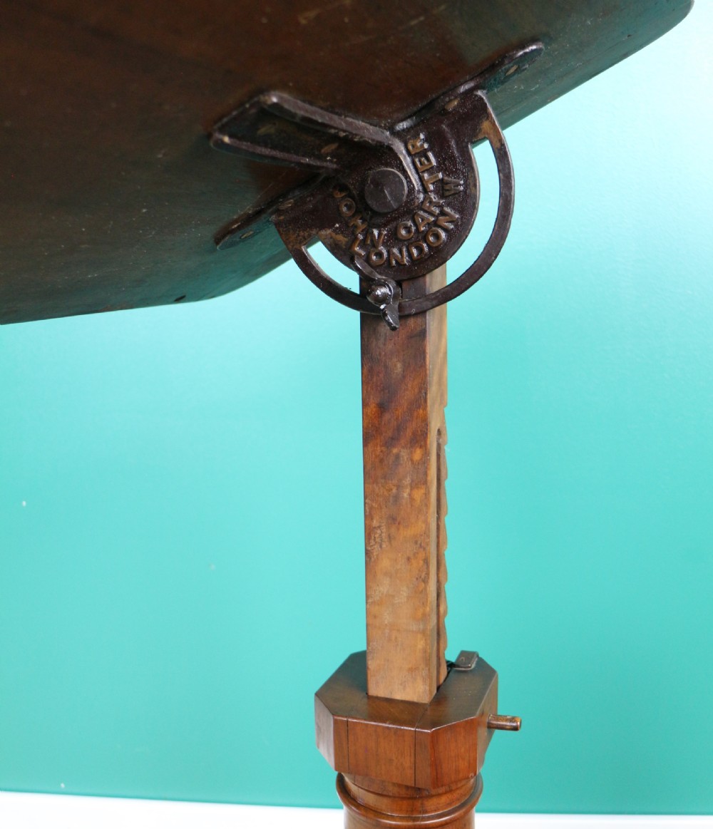 A Victorian mahogany adjustable reading table featuring a ratchet height mechanism, tilted top ledge, turned pedestal, and curved base on castors. View XVI