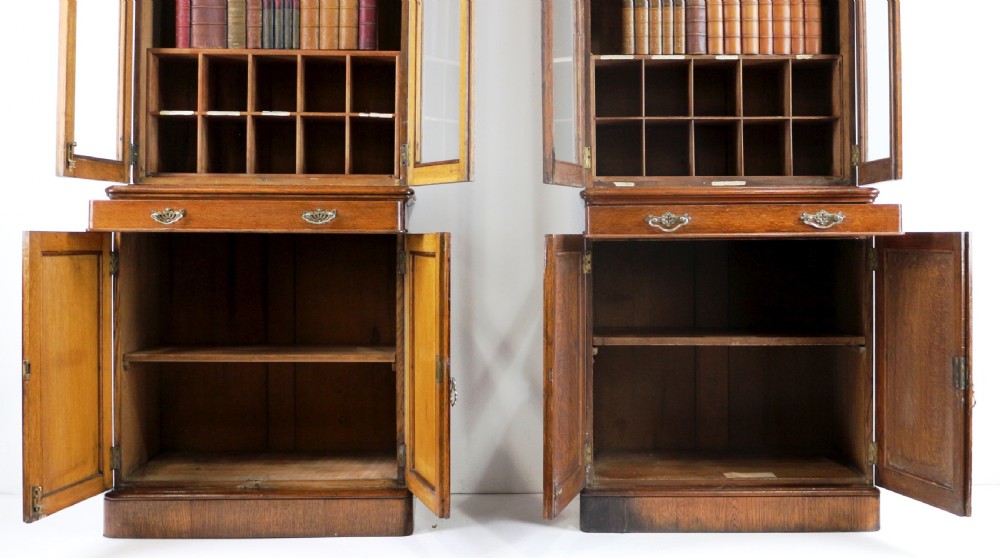A pair of tall, narrow late Victorian oak glazed bookcases with spindle gallery tops and lower panelled cupboard bases. View XII