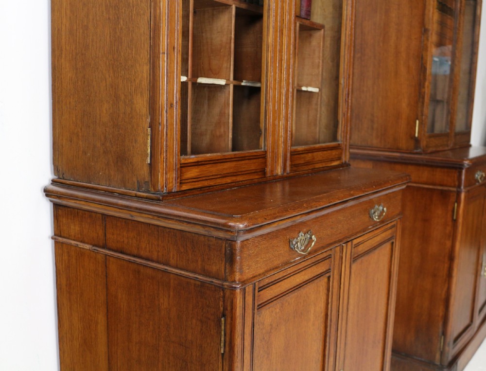 A pair of tall, narrow late Victorian oak glazed bookcases with spindle gallery tops and lower panelled cupboard bases. View XXIV