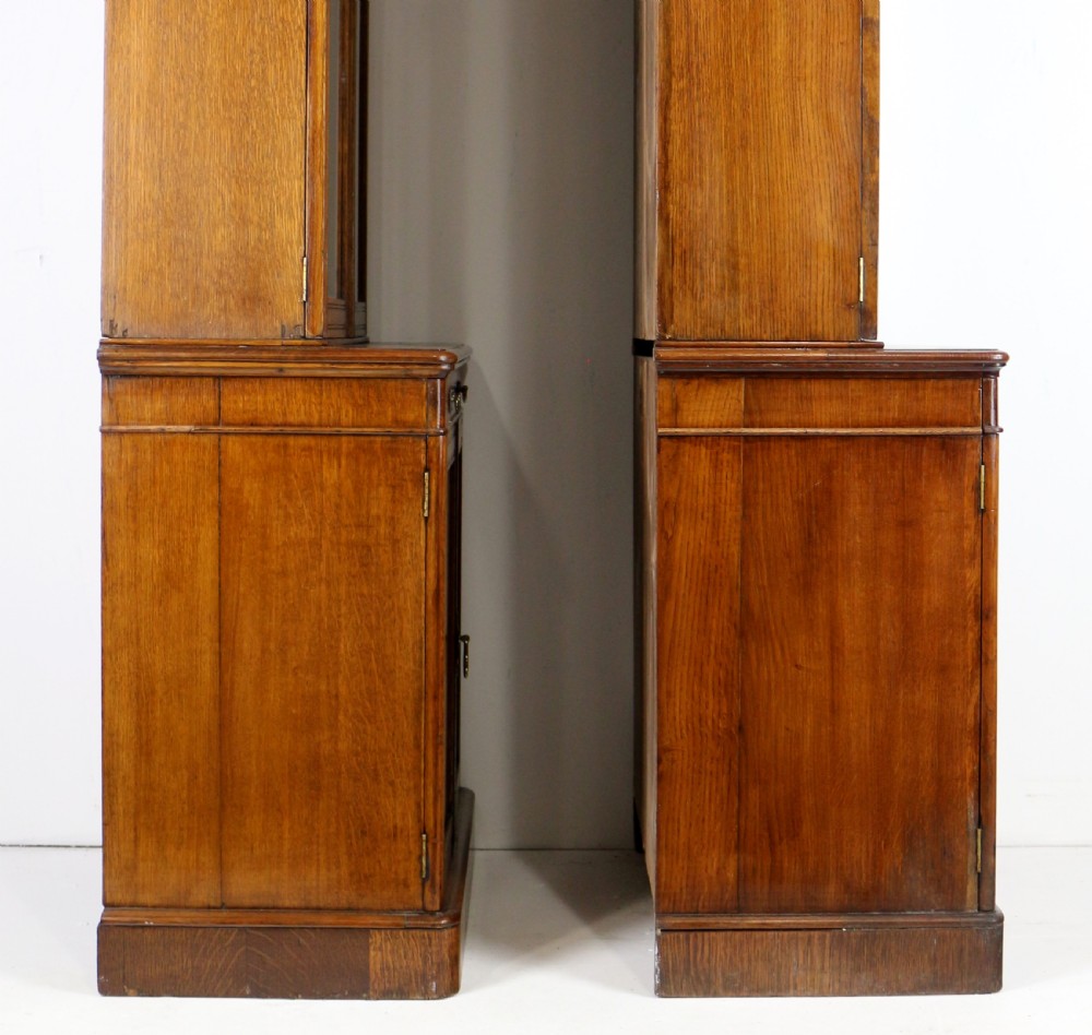 A pair of tall, narrow late Victorian oak glazed bookcases with spindle gallery tops and lower panelled cupboard bases. View XXVIII