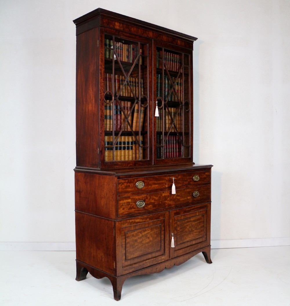 A George III mahogany secretaire bookcase featuring twin astragal glazed doors above a fitted writing drawer and lower panelled doors. View II