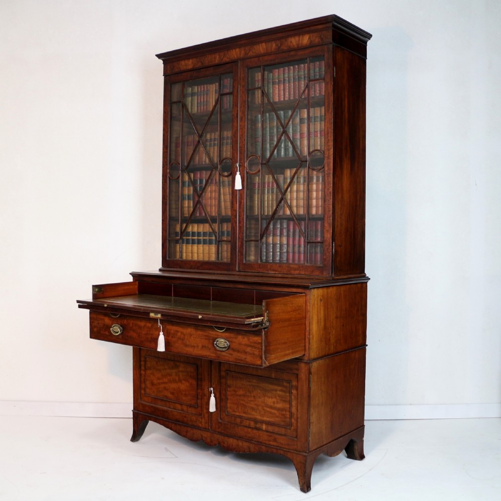 A George III mahogany secretaire bookcase featuring twin astragal glazed doors above a fitted writing drawer and lower panelled doors. View III