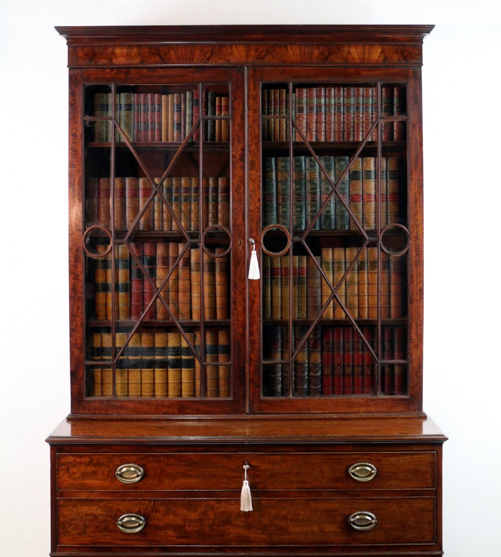 A George III mahogany secretaire bookcase featuring twin astragal glazed doors above a fitted writing drawer and lower panelled doors. View IV
