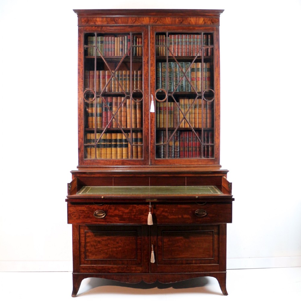 A George III mahogany secretaire bookcase featuring twin astragal glazed doors above a fitted writing drawer and lower panelled doors. View V