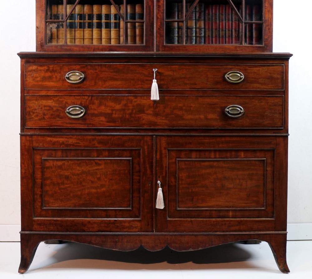 A George III mahogany secretaire bookcase featuring twin astragal glazed doors above a fitted writing drawer and lower panelled doors. View VI