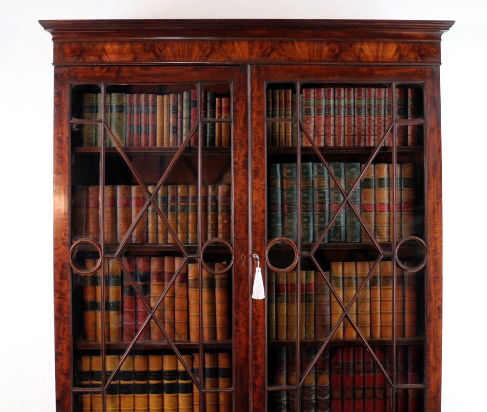 A George III mahogany secretaire bookcase featuring twin astragal glazed doors above a fitted writing drawer and lower panelled doors. View VII
