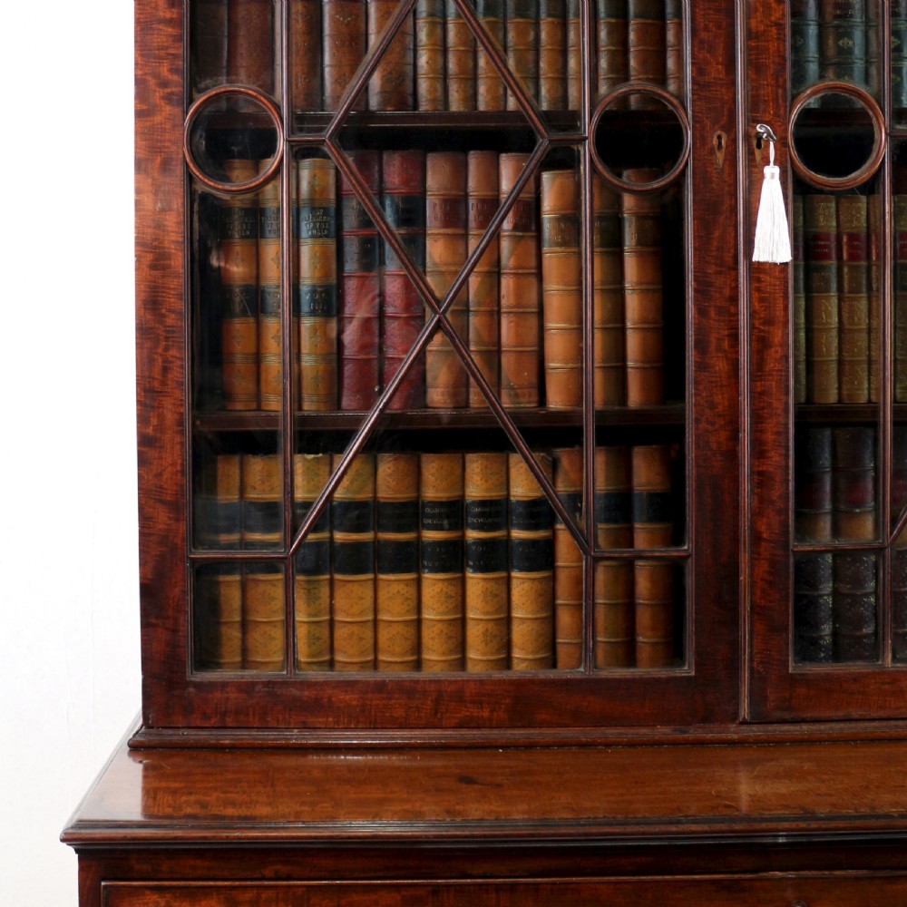 A George III mahogany secretaire bookcase featuring twin astragal glazed doors above a fitted writing drawer and lower panelled doors. View VIII