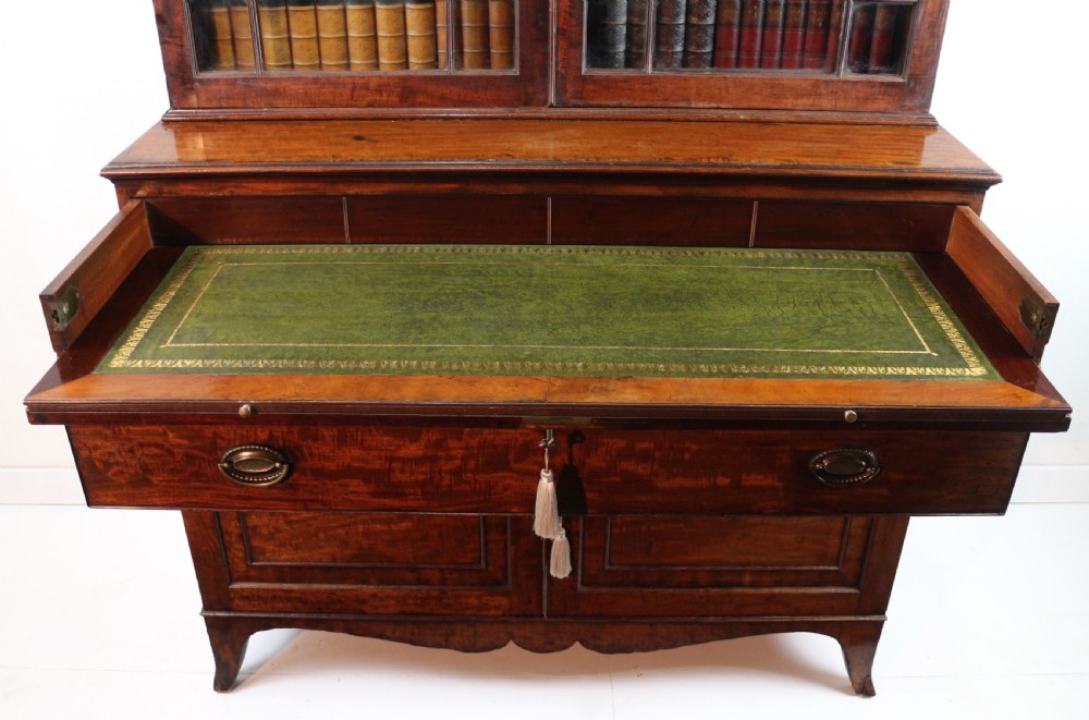 A George III mahogany secretaire bookcase featuring twin astragal glazed doors above a fitted writing drawer and lower panelled doors. View XVI