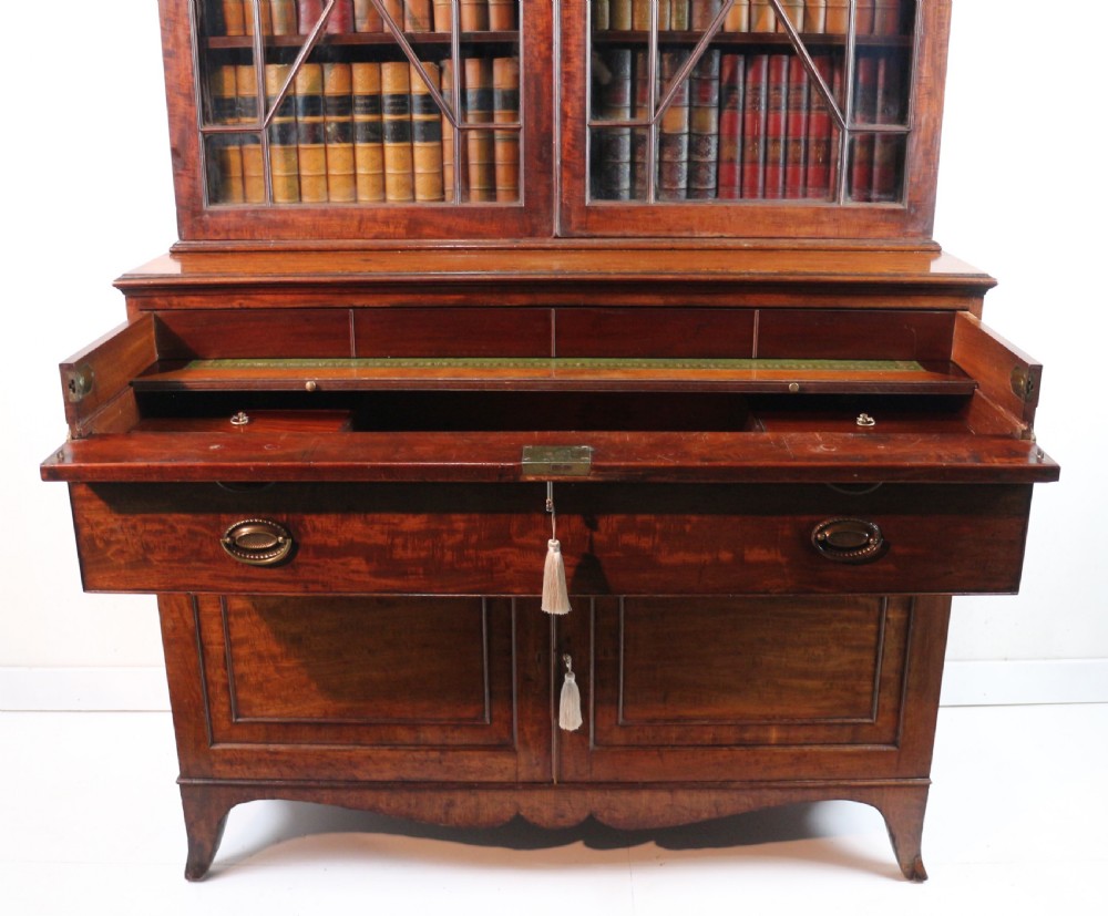 A George III mahogany secretaire bookcase featuring twin astragal glazed doors above a fitted writing drawer and lower panelled doors. View XX