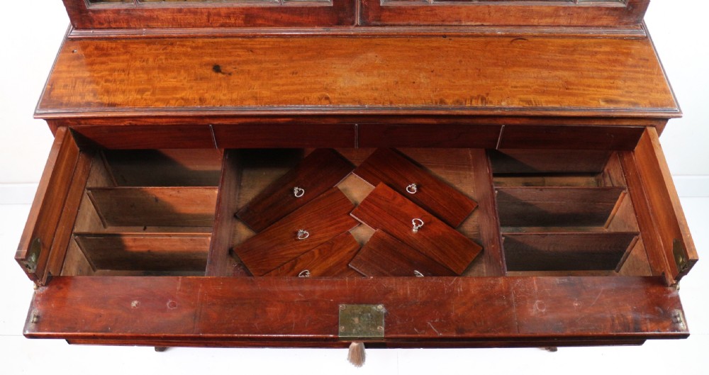 A George III mahogany secretaire bookcase featuring twin astragal glazed doors above a fitted writing drawer and lower panelled doors. View XXII