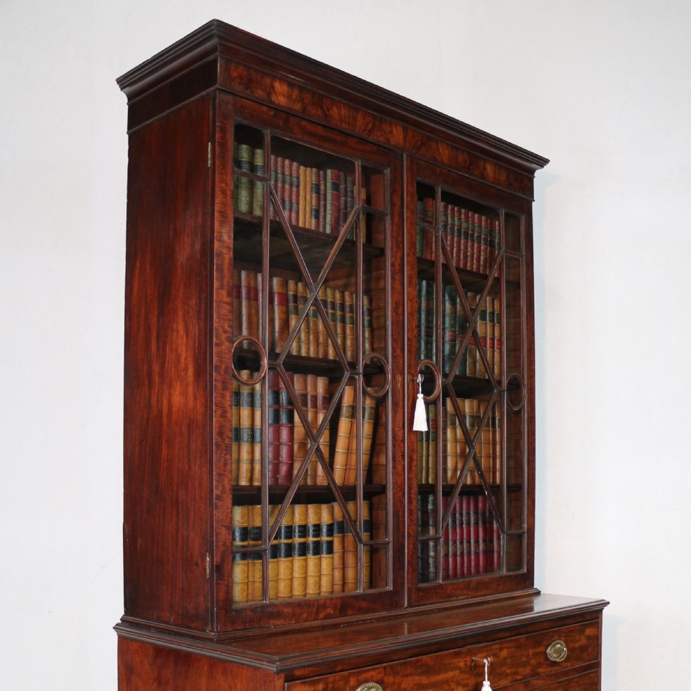A George III mahogany secretaire bookcase featuring twin astragal glazed doors above a fitted writing drawer and lower panelled doors. View XXIV