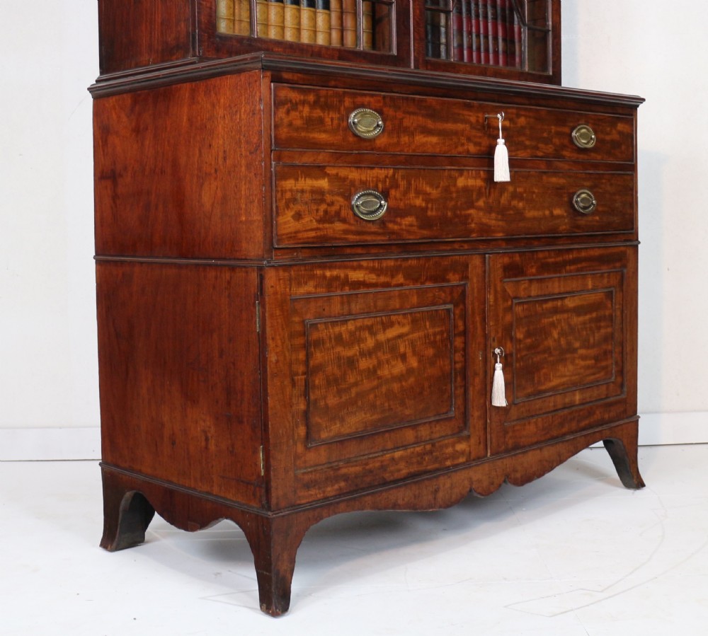 A George III mahogany secretaire bookcase featuring twin astragal glazed doors above a fitted writing drawer and lower panelled doors. View XXV