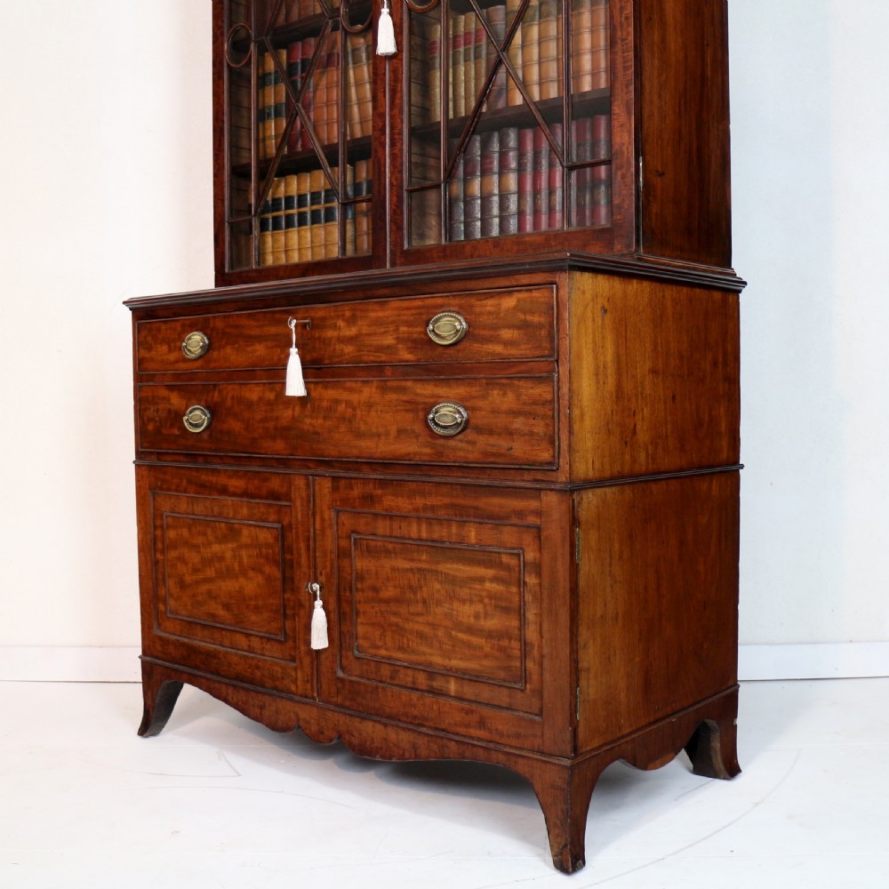 A George III mahogany secretaire bookcase featuring twin astragal glazed doors above a fitted writing drawer and lower panelled doors. View XXVII