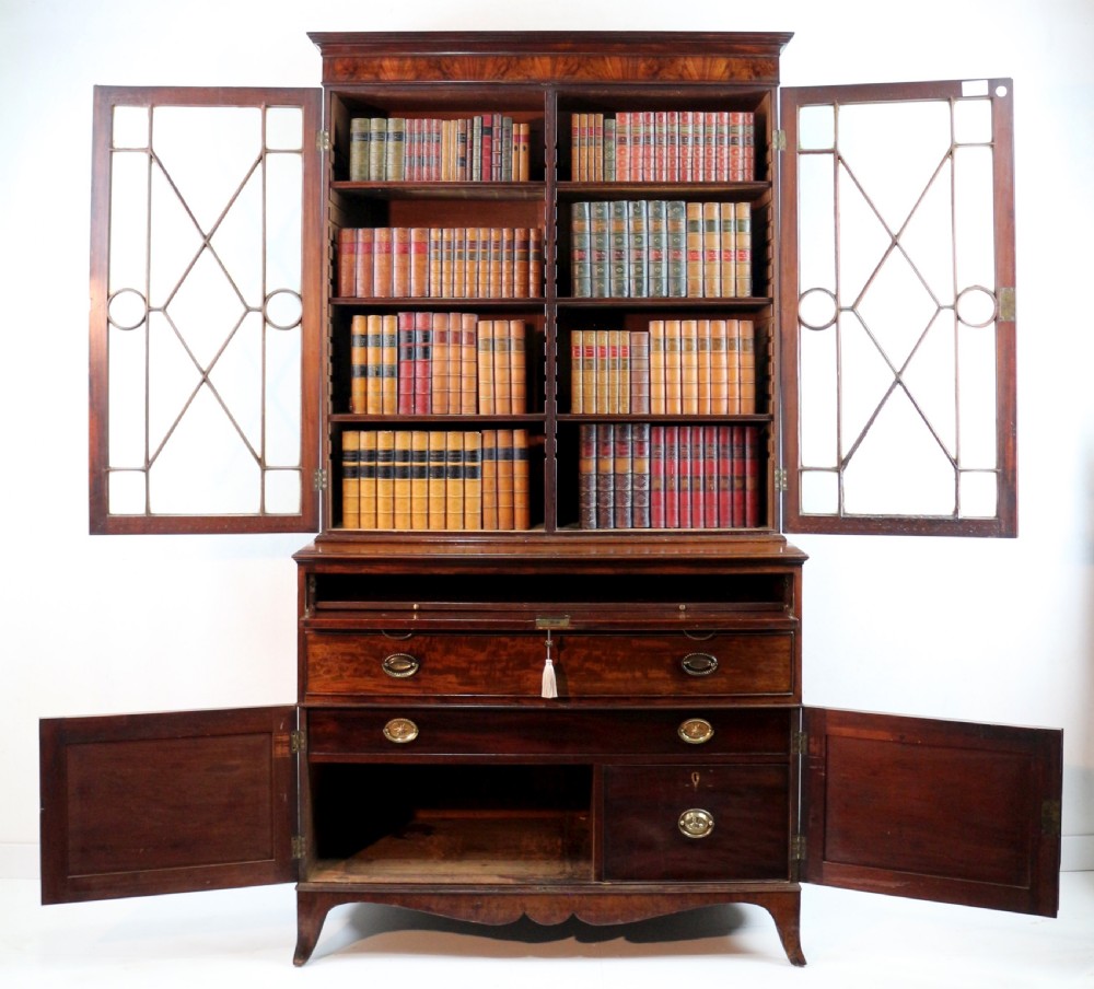 A George III mahogany secretaire bookcase featuring twin astragal glazed doors above a fitted writing drawer and lower panelled doors. View XXVIII