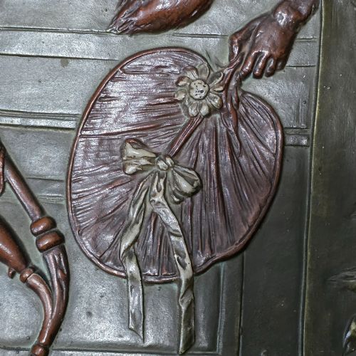 fig 6. An oval dark brown Austrian terracotta relief plaque depicting a satirical scene of an anthropomorphic monkey family framed by relief floral motifs.