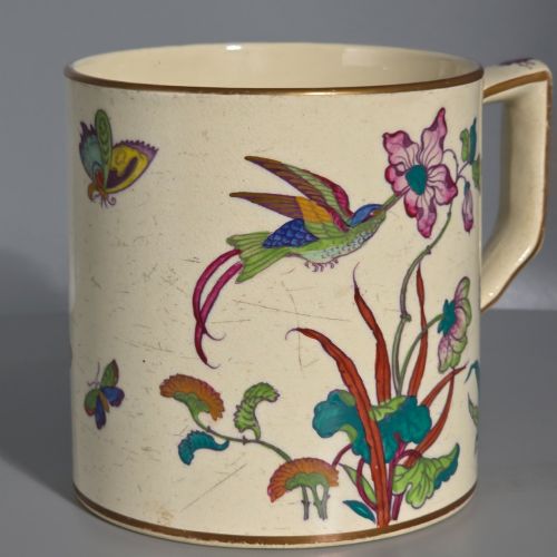 fig 2. A large cream porcelain mug decorated with hand-painted polychrome birds, insects, flowers, and a gilded rim.