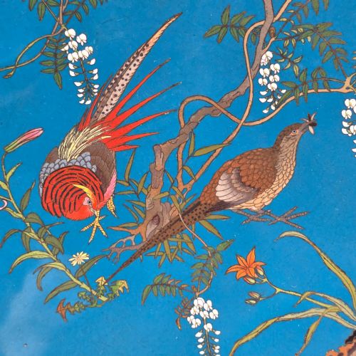fig 2. A circular Japanese Meiji period cloisonne enamel charger depicting birds perched on branches with flowers against a bright blue background.
