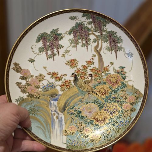 fig 1. A circular Satsuma earthenware dish decorated with hand-painted pheasants, wisteria, flowers, and a waterfall with gilt accents.