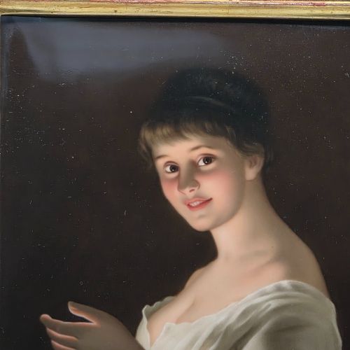 fig 2. A nineteenth-century framed hand-painted KPM porcelain plaque featuring a young woman holding a lit candle against a dark background.