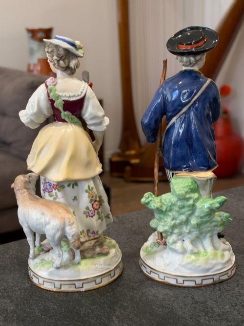 fig 3. A pair of antique hand-painted German porcelain figures depicting a shepherdess with a lamb and a shepherd holding a basket, set on circular gilded bases.
