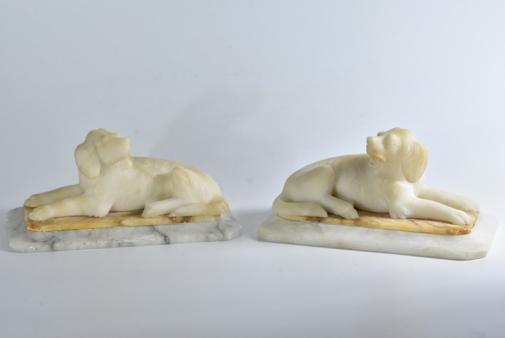 Fine pair of vintage carved alabaster recumbent dogs on a marble base c1900