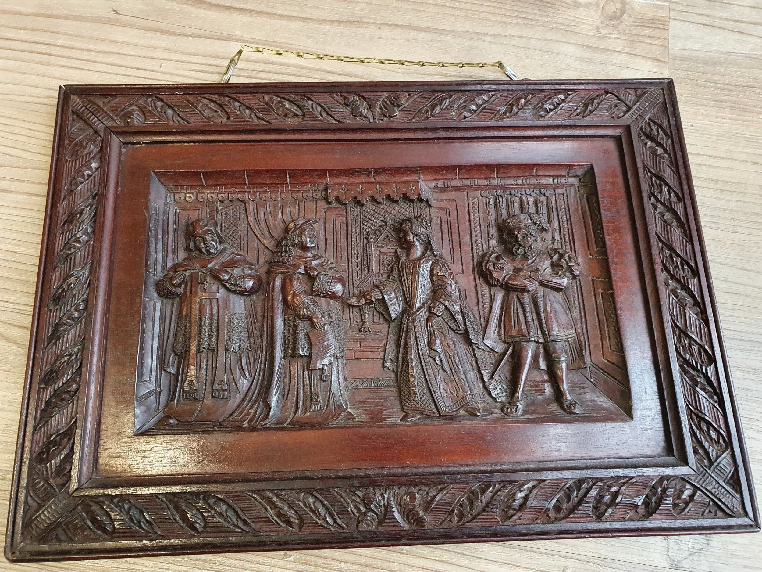 A Victorian Mahogany Carved Relief Panel Depicting Tudor Interior Scene