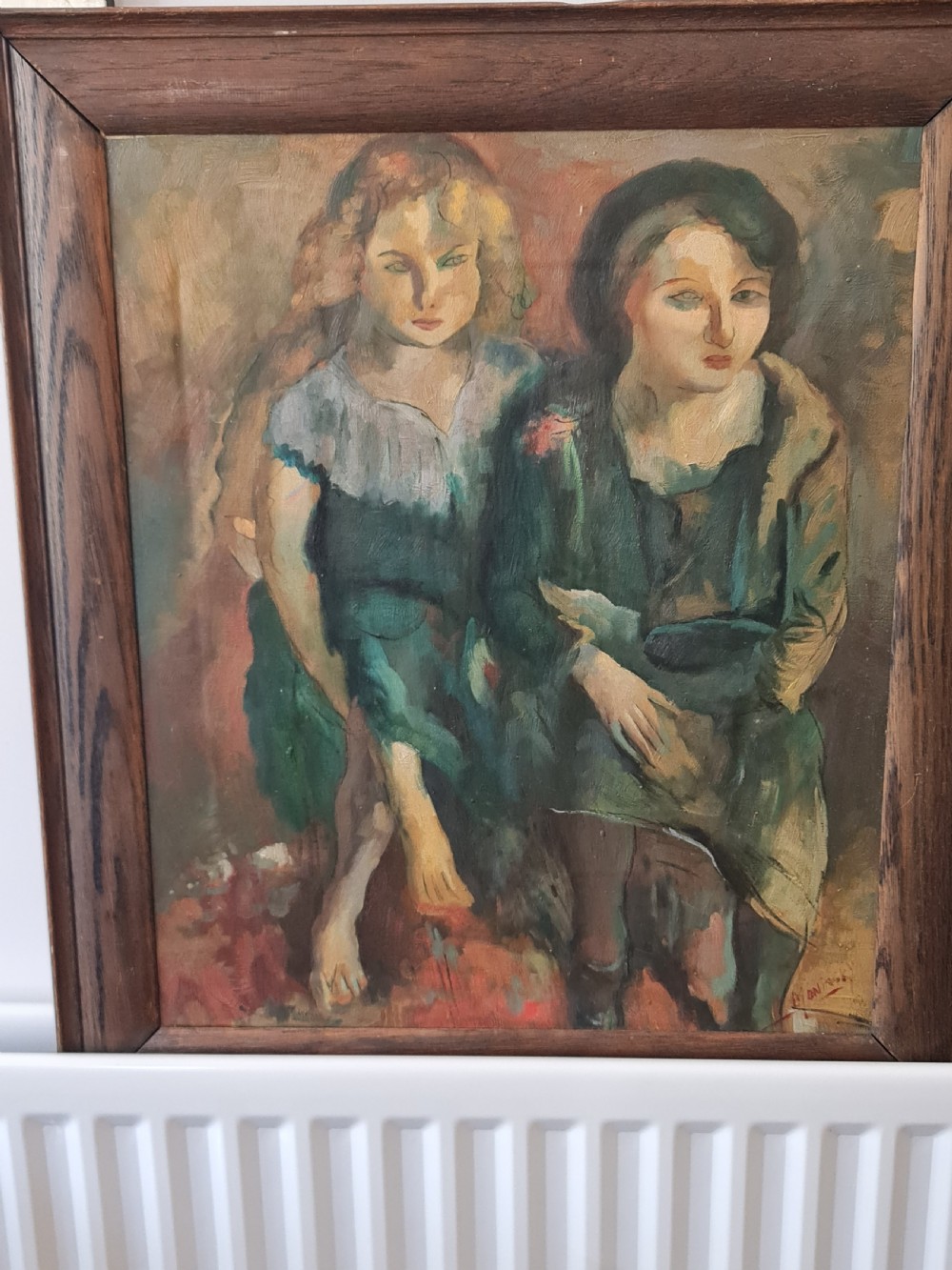 A mid-20th-century figurative oil painting depicting two female figures rendered in muted green, ochre, and brown tones, encased within a dark oak frame. View V