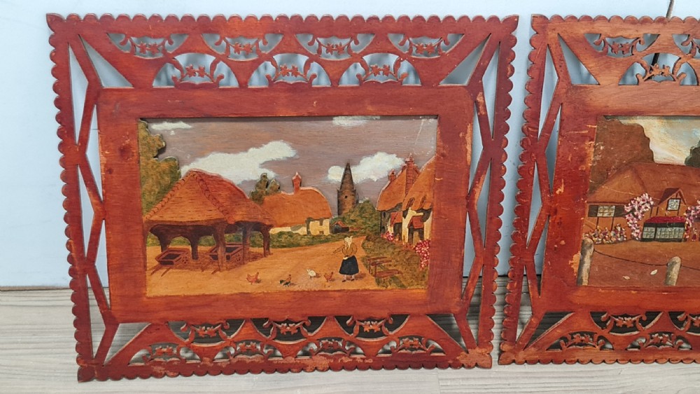 A pair of framed three-dimensional wooden folk art pictures featuring rural village scenes set within fretted reddish-brown frames. View II