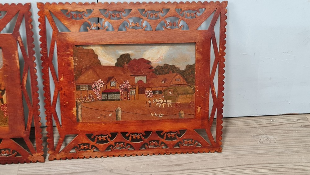 A pair of framed three-dimensional wooden folk art pictures featuring rural village scenes set within fretted reddish-brown frames. View III