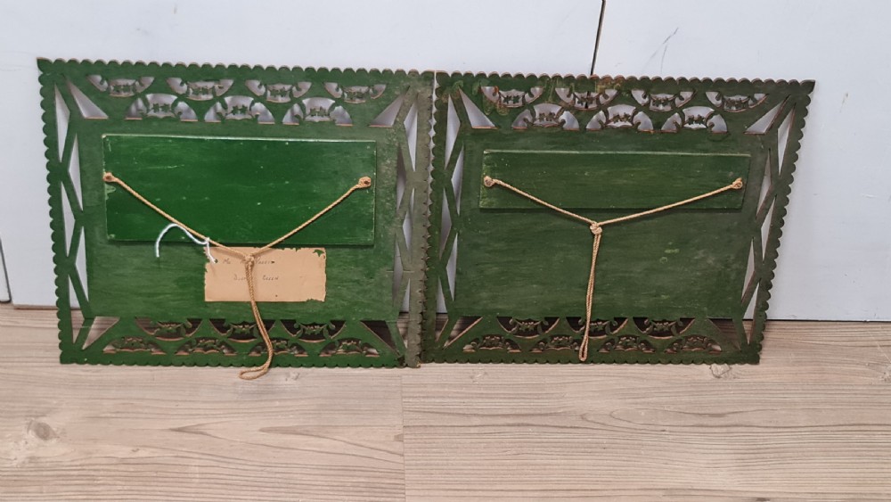 A pair of framed three-dimensional wooden folk art pictures featuring rural village scenes set within fretted reddish-brown frames. View VIII