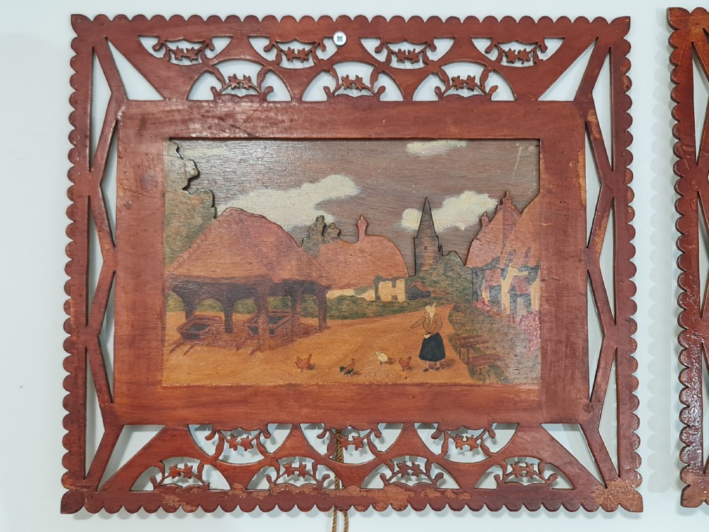 A pair of framed three-dimensional wooden folk art pictures featuring rural village scenes set within fretted reddish-brown frames. View IX