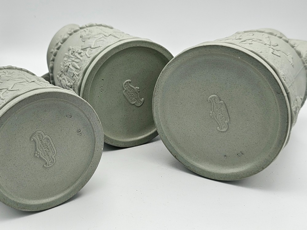A set of three graduated sage green ceramic jugs decorated with detailed relief-moulded scenes of knights and foliate scrollwork. View X