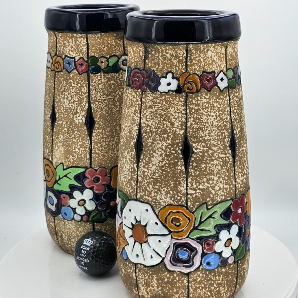 A pair of cylindrical Austrian ceramic vases featuring a textured beige ground, black rim, vertical cutouts, and colourful enamelled floral bands. View XIV