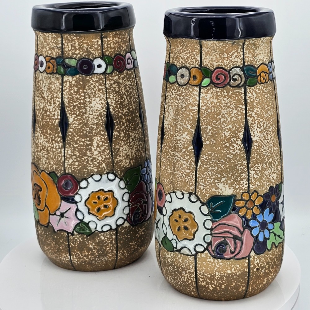 A pair of cylindrical Austrian ceramic vases featuring a textured beige ground, black rim, vertical cutouts, and colourful enamelled floral bands. View II