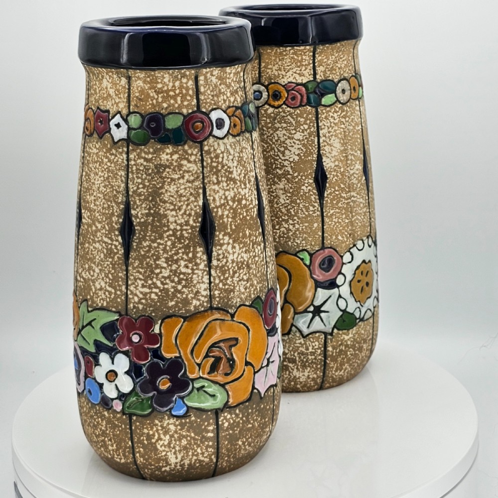 A pair of cylindrical Austrian ceramic vases featuring a textured beige ground, black rim, vertical cutouts, and colourful enamelled floral bands. View XVIII