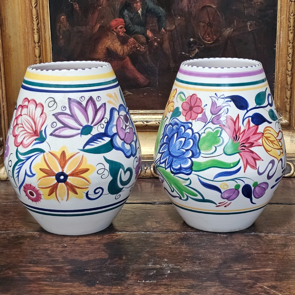 A pair of ovoid off-white ceramic vases decorated with hand-painted floral motifs in pink, purple, blue, green, and yellow. View II