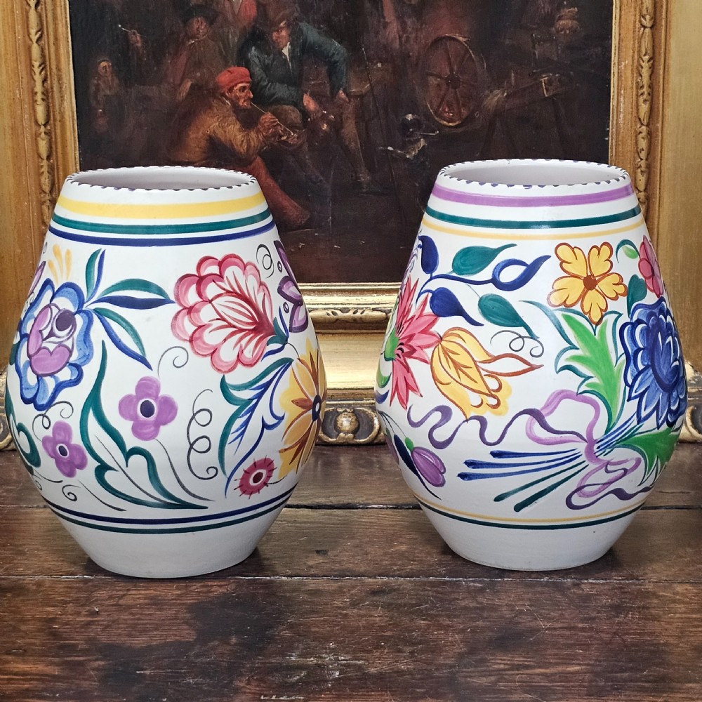 A pair of ovoid off-white ceramic vases decorated with hand-painted floral motifs in pink, purple, blue, green, and yellow. View III