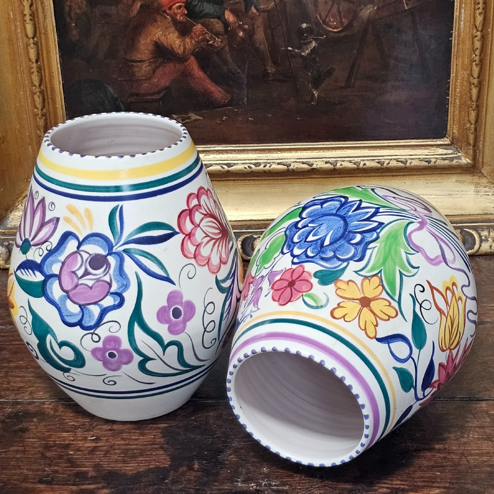 A pair of ovoid off-white ceramic vases decorated with hand-painted floral motifs in pink, purple, blue, green, and yellow. View VII