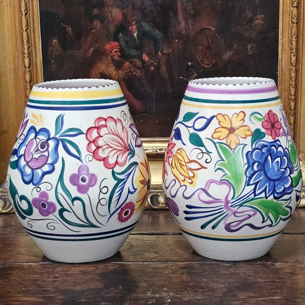 A pair of ovoid off-white ceramic vases decorated with hand-painted floral motifs in pink, purple, blue, green, and yellow. View IX