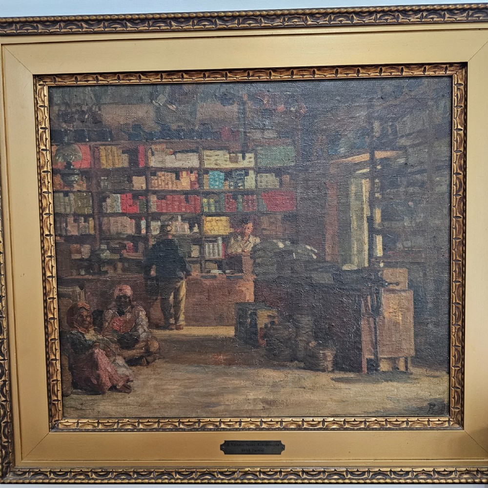 A framed oil painting depicting the interior of a village store in Namaqualand with seated figures and shelves of merchandise, set within a wide gold moulded frame. View III