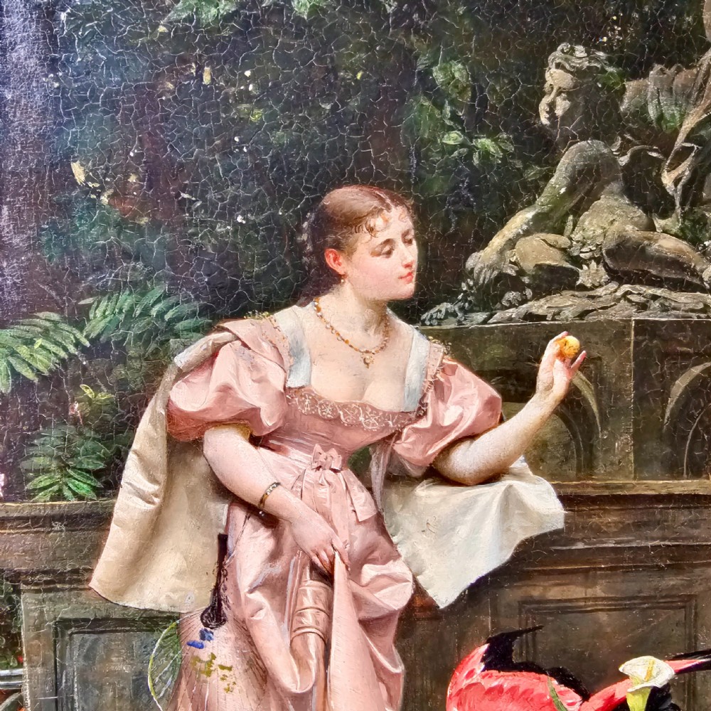 An 1880 framed oil painting depicting a woman in a pink dress beside a garden fountain with birds, presented in a heavily carved gilded frame. View III
