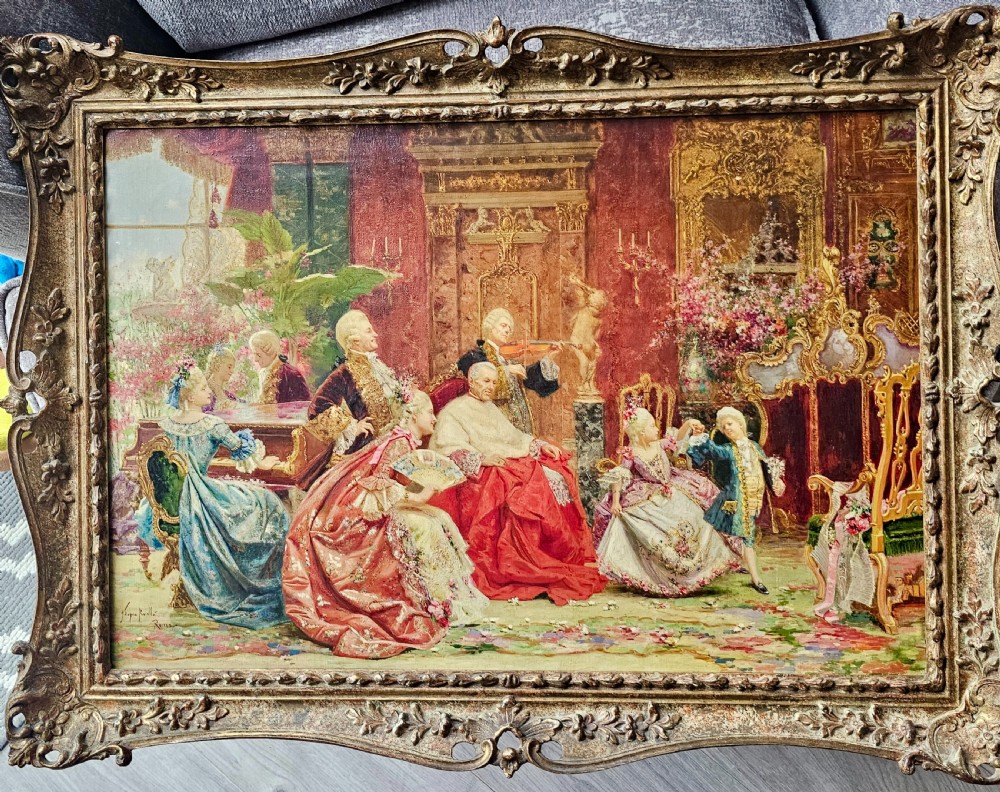 An antique oil on canvas painting by Joaquin Luque y Rosello depicting an elaborate 18th-century aristocratic salon gathering in a highly ornate gilt frame.