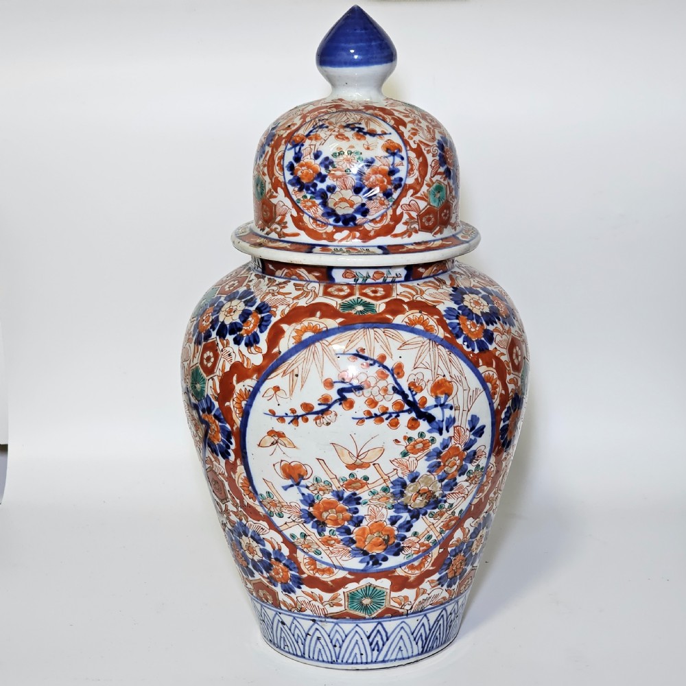 A 19th-century Japanese Imari porcelain ginger jar with a domed finial lid, decorated in hand-painted iron-red and cobalt blue floral cartouches. View III