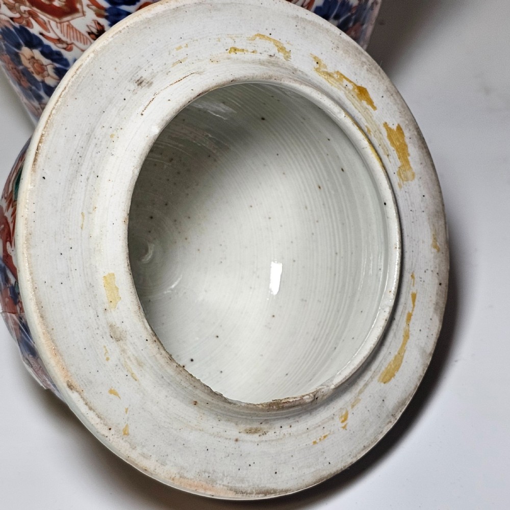 A 19th-century Japanese Imari porcelain ginger jar with a domed finial lid, decorated in hand-painted iron-red and cobalt blue floral cartouches. View VII