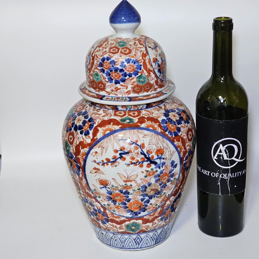 A 19th-century Japanese Imari porcelain ginger jar with a domed finial lid, decorated in hand-painted iron-red and cobalt blue floral cartouches. View VIII
