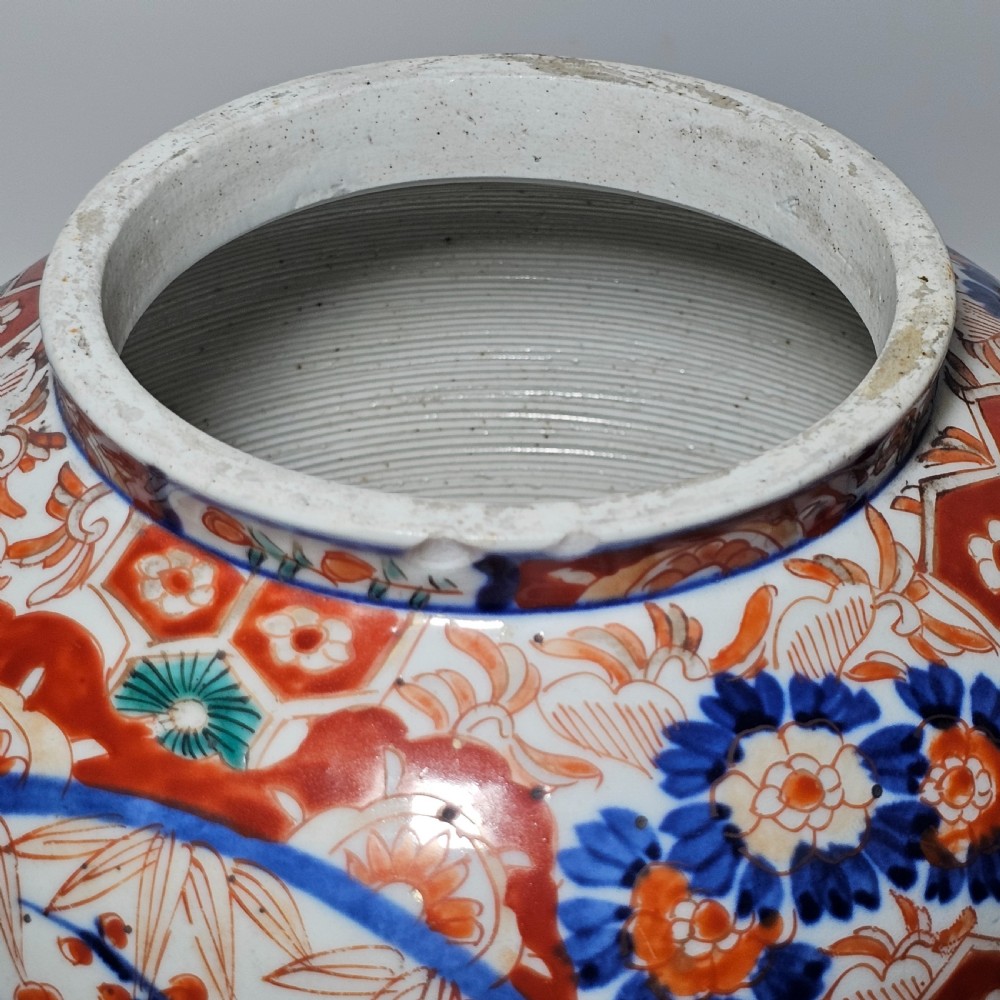 A 19th-century Japanese Imari porcelain ginger jar with a domed finial lid, decorated in hand-painted iron-red and cobalt blue floral cartouches. View XIII