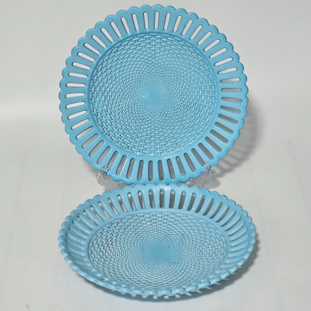 A pair of round pale blue opaque pressed glass dishes featuring openwork fretted rims and an embossed basketweave pattern in the centre.