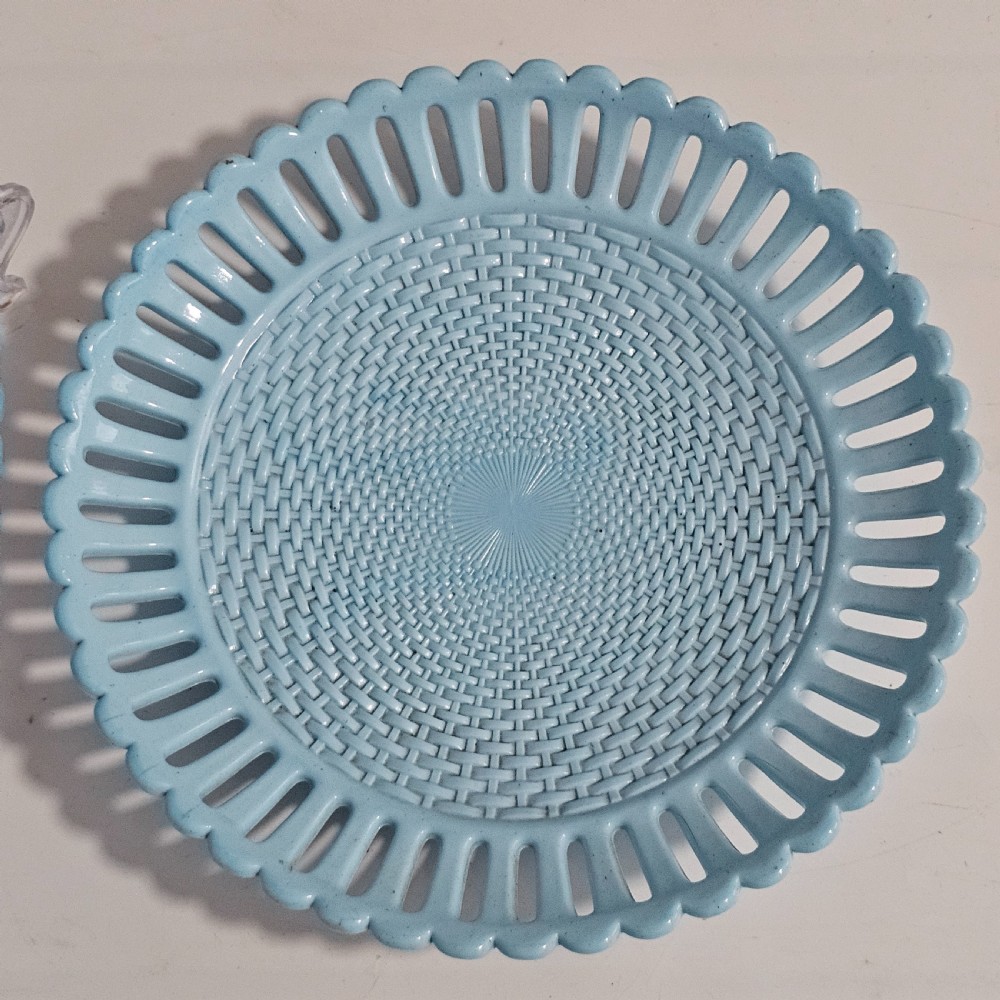A pair of round pale blue opaque pressed glass dishes featuring openwork fretted rims and an embossed basketweave pattern in the centre. View II