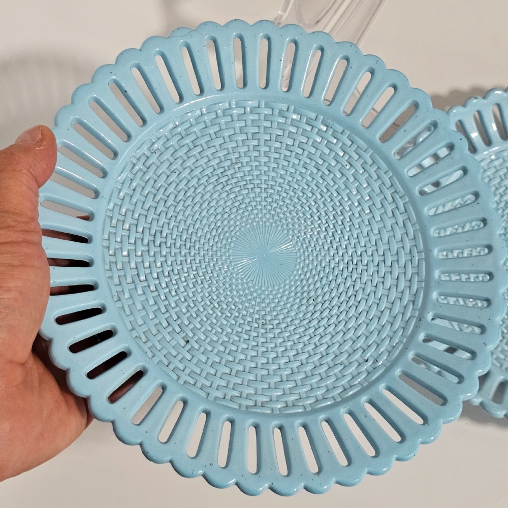 A pair of round pale blue opaque pressed glass dishes featuring openwork fretted rims and an embossed basketweave pattern in the centre. View VI