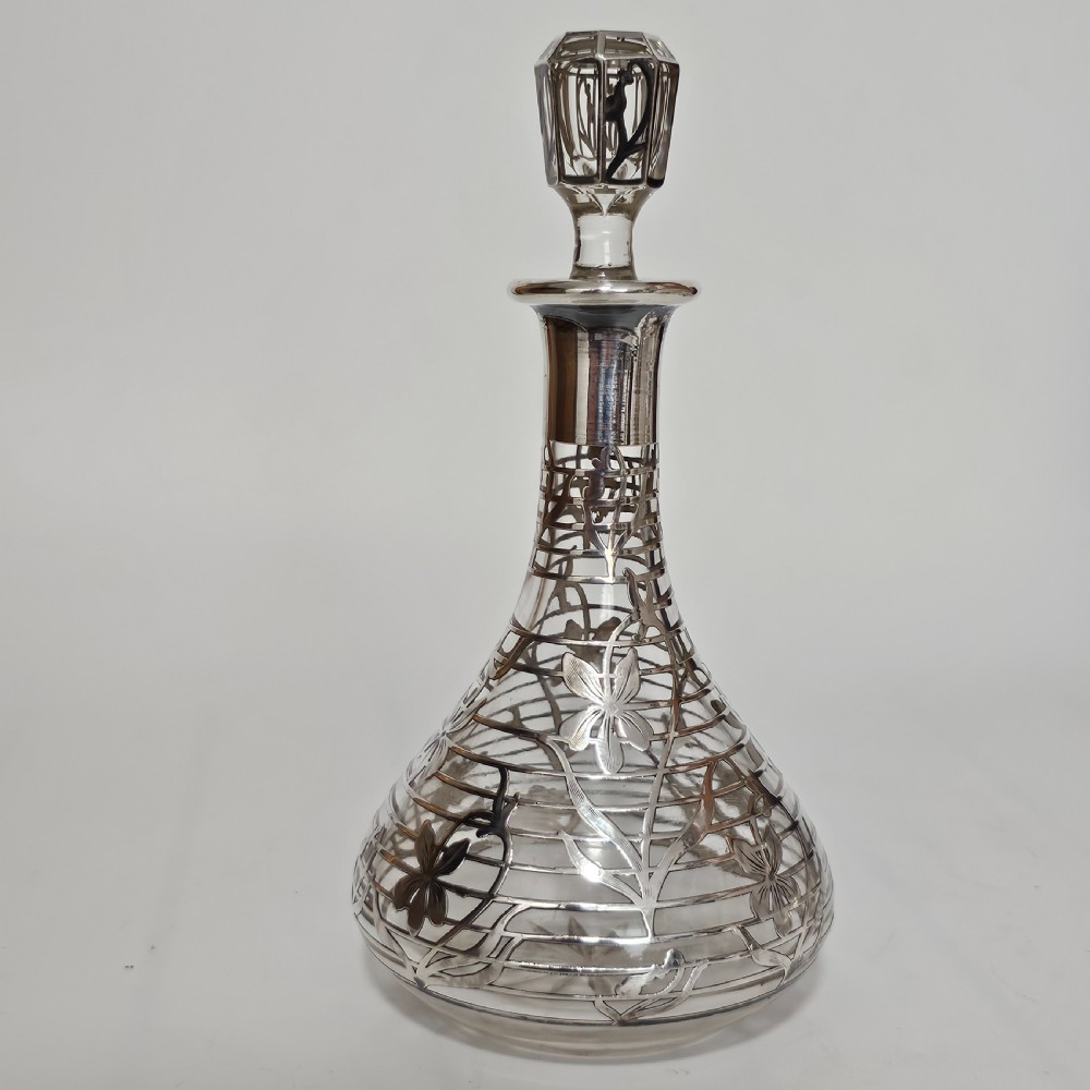 An early 20th-century glass decanter featuring an intricate sterling silver floral overlay and matching stopper. View IV